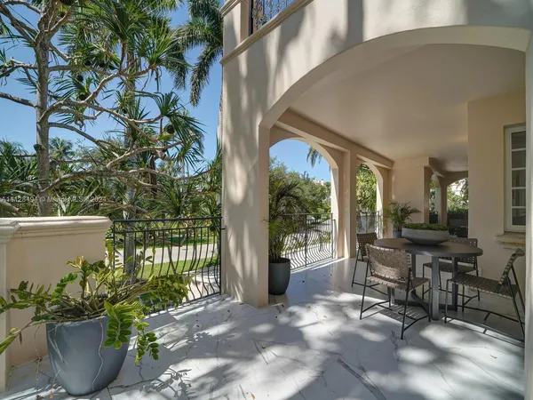 a view of a patio with couches and a fire pit and wooden fence