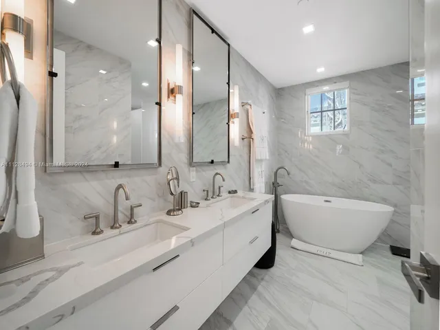 a bathroom with a double vanity sink mirror and bathtub
