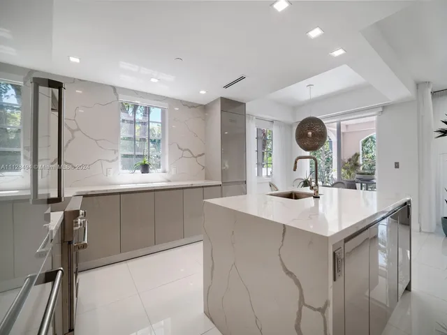 a kitchen with kitchen island a sink appliances and a large window