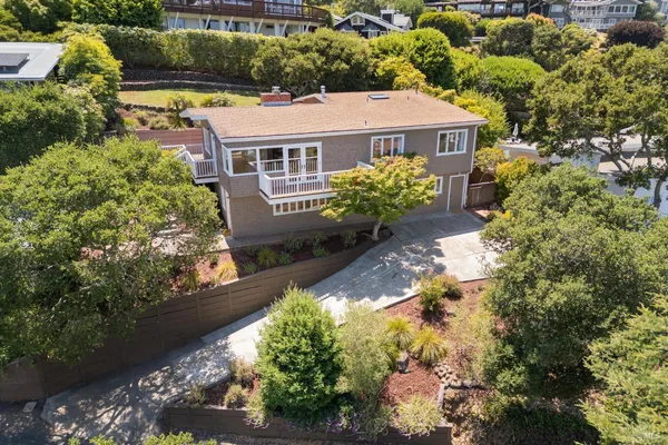 a aerial view of a house with a yard and a large tree