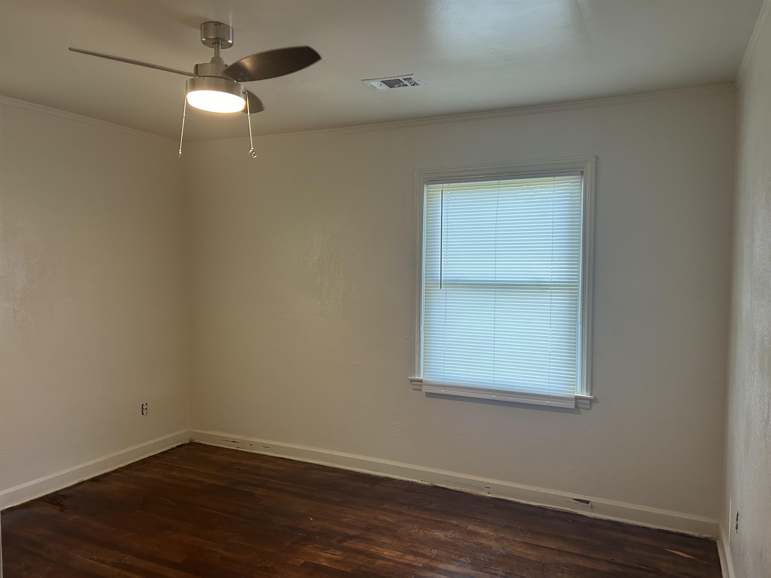 904 North Ball Road Memphis, TN 38106 - Photo 8 of 12 Interior room featuring a single window with blinds, a ceiling fan with integrated lighting, wood-finish flooring, and white baseboards
