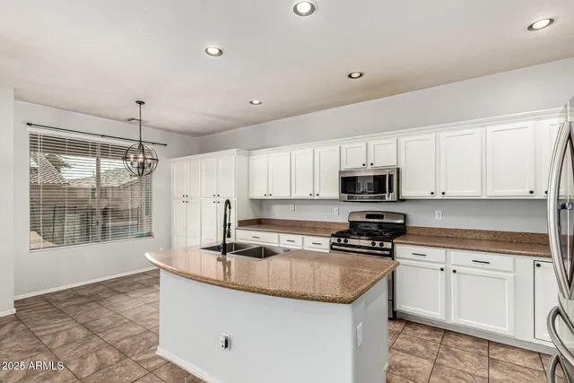 a kitchen with granite countertop a sink stainless steel appliances and cabinets