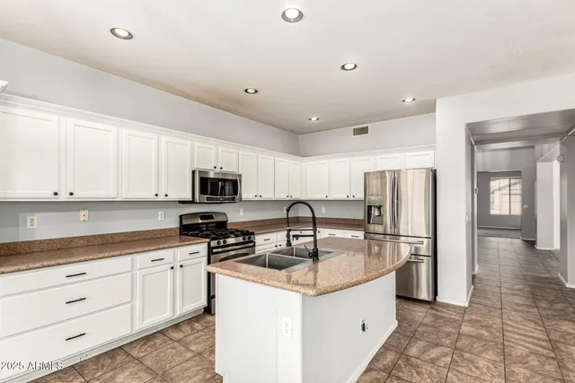 a kitchen with stainless steel appliances granite countertop a sink a stove and a refrigerator