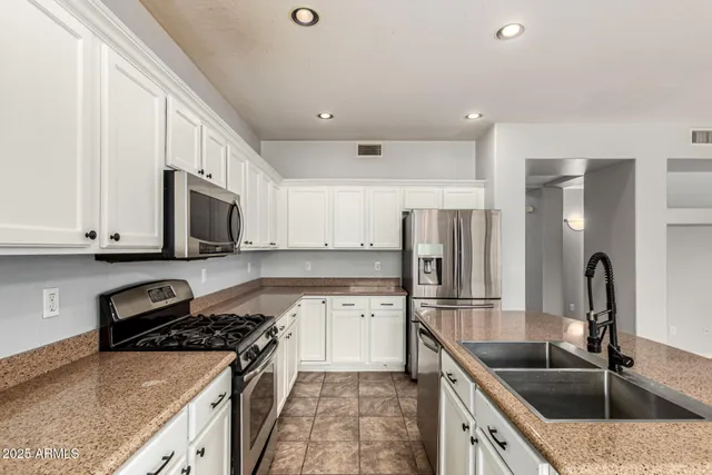 a kitchen with stainless steel appliances granite countertop a sink stove and refrigerator