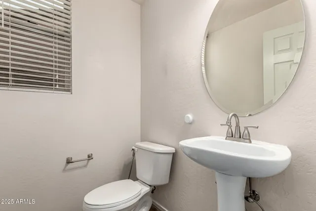 a bathroom with a toilet a sink and mirror