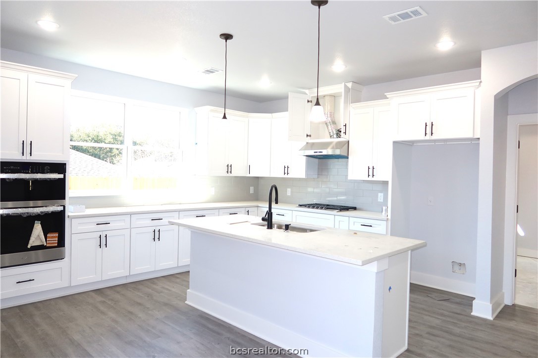 2008 Reagan Court Bryan, TX 77802 - Photo 7 of 21 a kitchen with a sink a stove a refrigerator and island