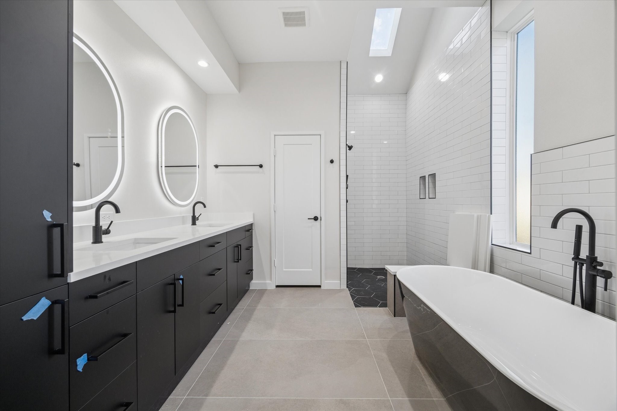 3902 Zina Way Houston, TX 77018 - Photo 16 of 48 a spacious bathroom with a double vanity sink a mirror a vanity and a bathtub