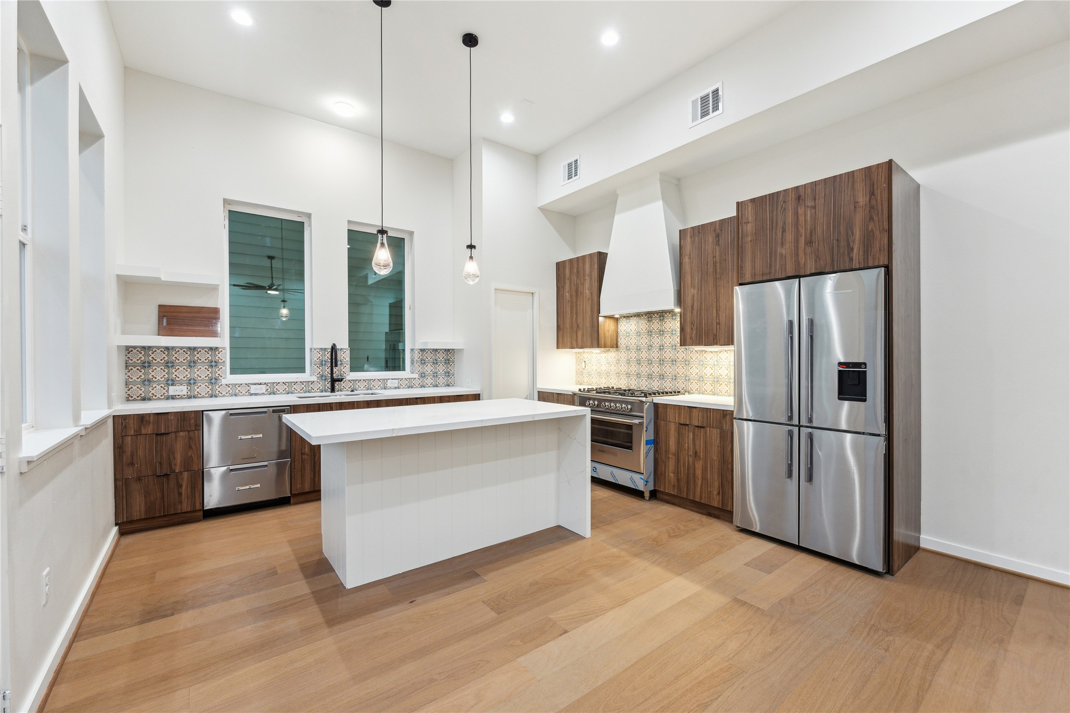 3902 Zina Way Houston, TX 77018 - Photo 9 of 48 a large kitchen with a large refrigerator a sink dishwasher a oven and a kitchen island with wooden floor