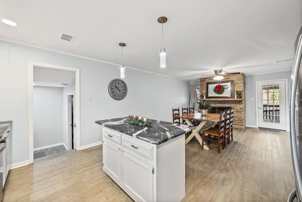 a open kitchen with stainless steel appliances granite countertop a stove and a wooden floors