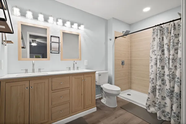 a bathroom with a double vanity sink mirror and toilet