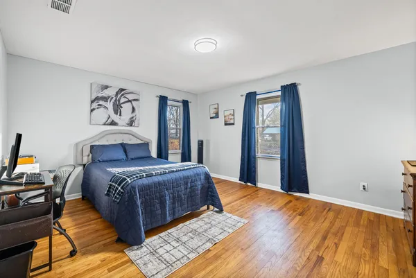 a bedroom with a bed and wooden floor