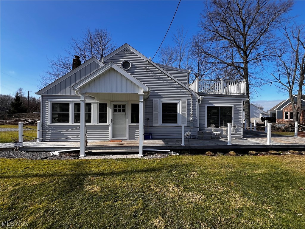 View of front of house with a front lawn and a wooden deck