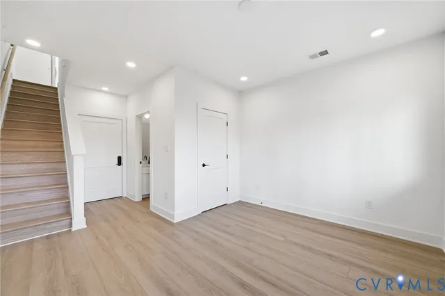 a view of an empty room with wooden floor