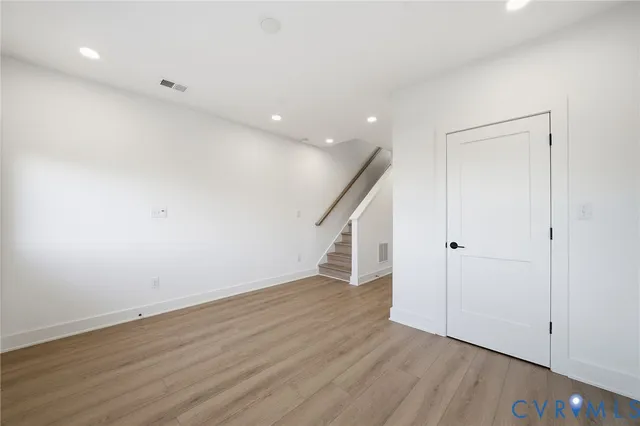 a view of an empty room with wooden floor
