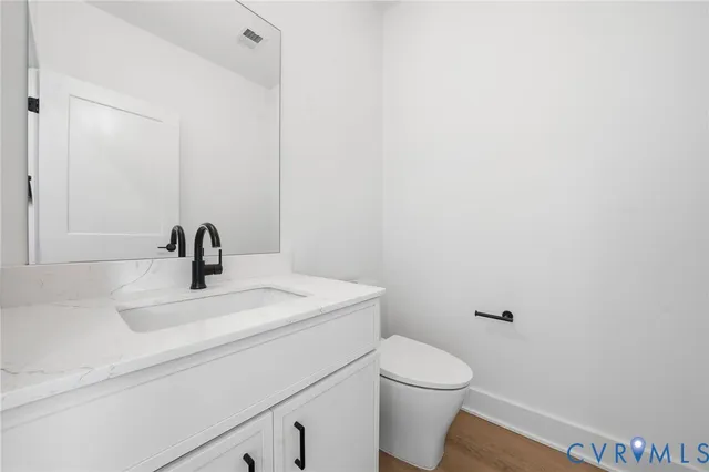 a bathroom with a sink a toilet and mirror