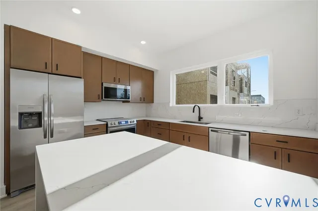 a kitchen with stainless steel appliances a sink microwave and refrigerator