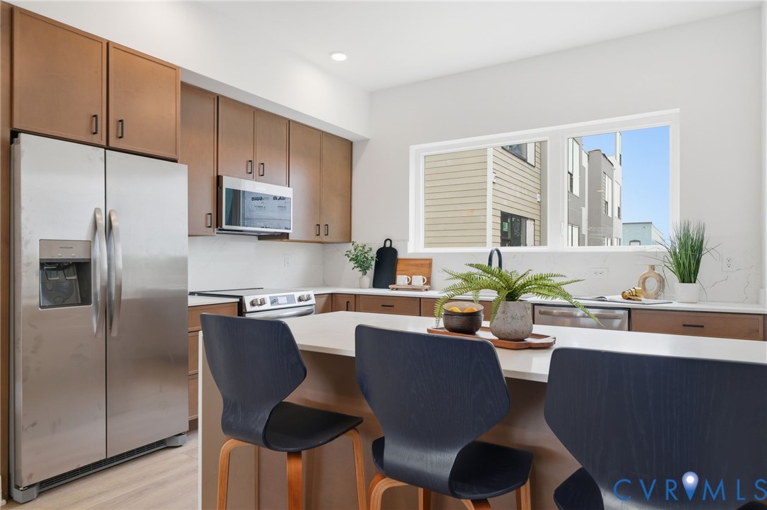 606 Decatur Street Richmond, VA 23224 - Photo 8 of 24 a kitchen with a dining table chairs and refrigerator