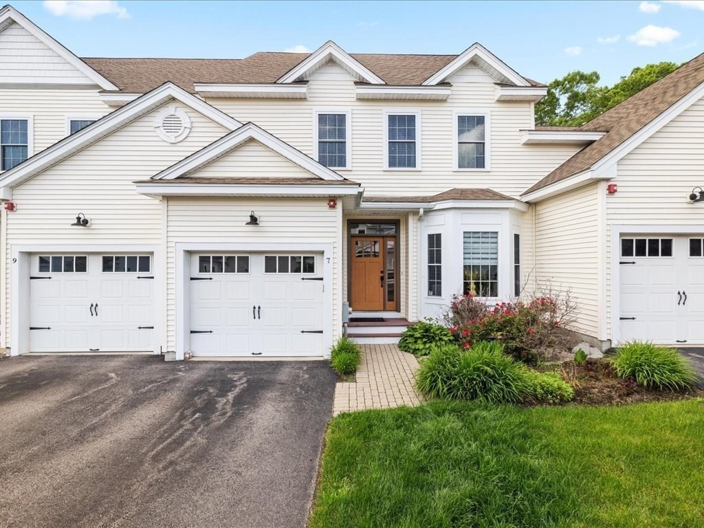 7 Garett Way, Unit 7 Holliston, MA 01746 - Photo 1 of 32 a view of white house with a small yard and potted plants