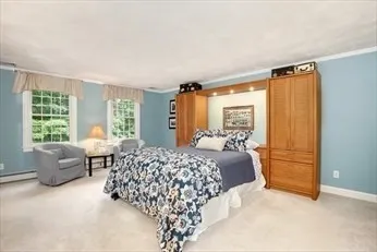 a bedroom with a bed and large windows