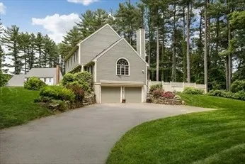 a front view of a house with a yard and trees