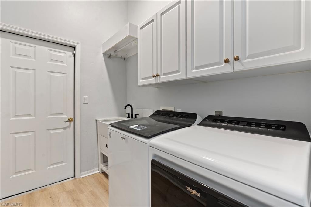 20751 Rivers Ford Estero, FL 33928 - Photo 28 of 36 Washroom with light wood-style flooring, cabinet space, and washing machine and clothes dryer