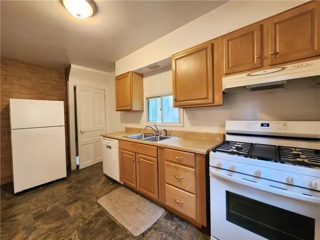 a kitchen with stainless steel appliances granite countertop a refrigerator stove and cabinets
