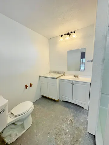 a view of an empty room with a fireplace and a window