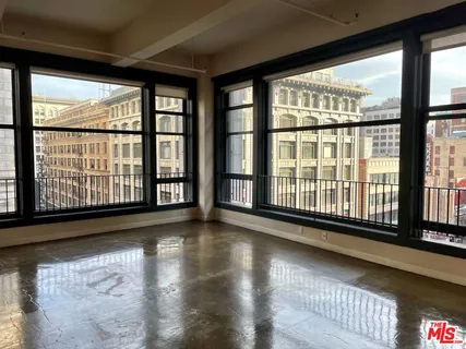 a view of empty room with wooden floor and floor to ceiling window