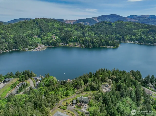 an aerial view of a house with a yard and lake view