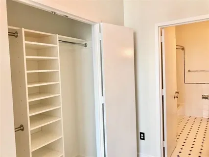 a view of walk in closet with empty racks