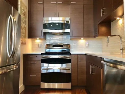 a kitchen with stainless steel appliances a stove a refrigerator and a sink