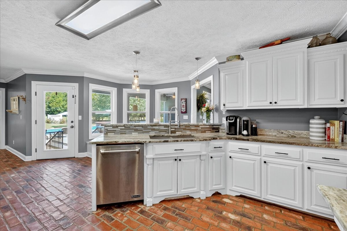 7225 Highway 57 Ramer, TN 38367 - Photo 13 of 68 a kitchen with granite countertop a stove a sink a refrigerator and white cabinets with wooden floor