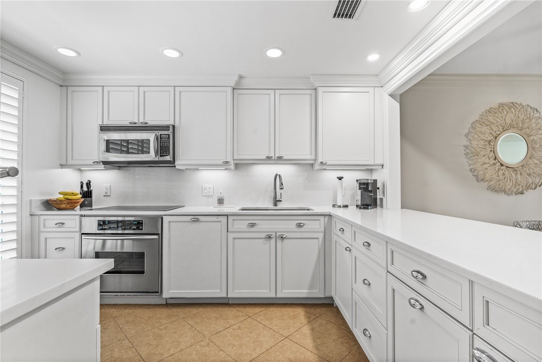 550 Beach Road, Unit 223 Vero Beach, FL 32963 - Photo 13 of 36 a kitchen with cabinets appliances a sink and a counter top space