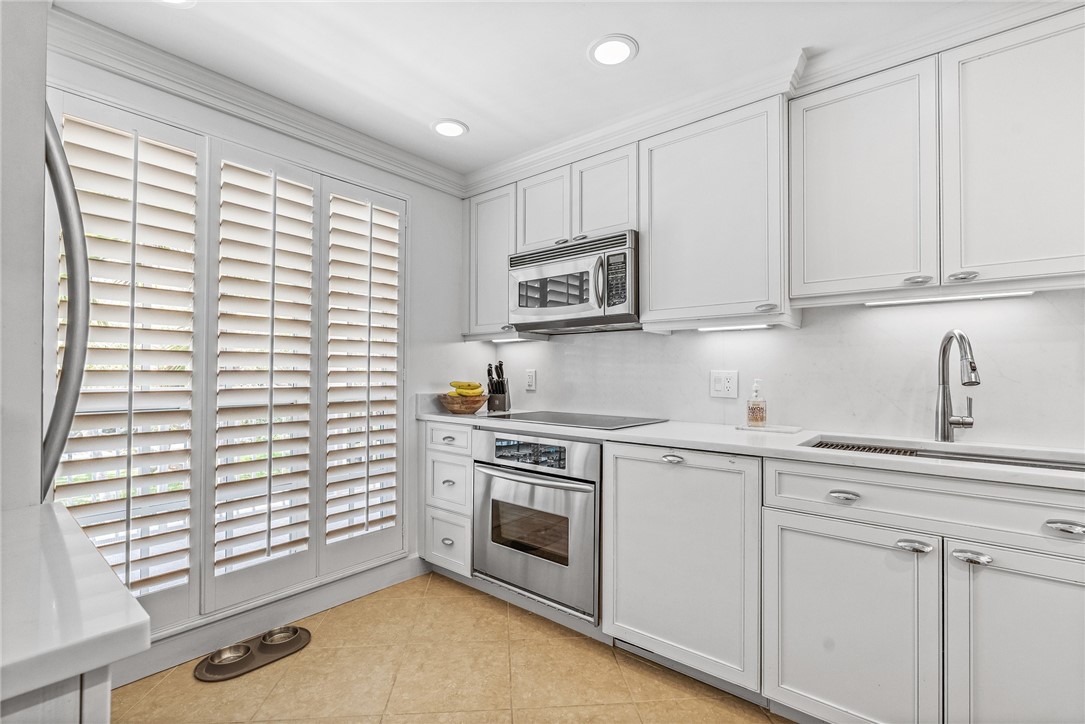 550 Beach Road, Unit 223 Vero Beach, FL 32963 - Photo 14 of 36 a kitchen with white cabinets and a stove top oven