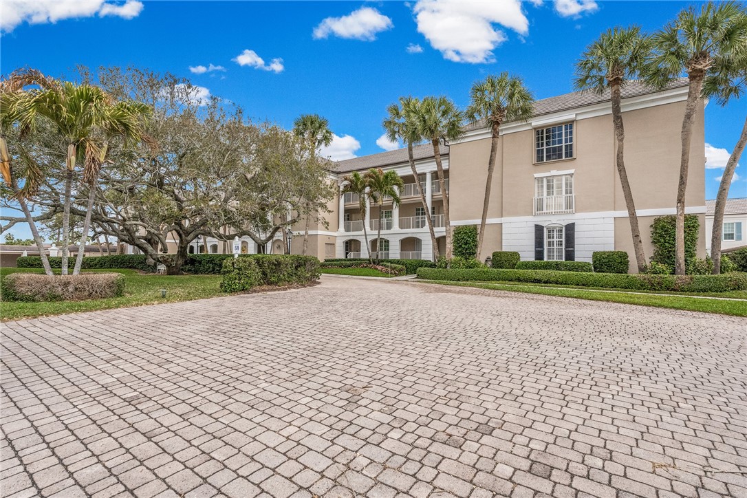 550 Beach Road, Unit 223 Vero Beach, FL 32963 - Photo 3 of 36 a view of a white house with a yard and potted plants