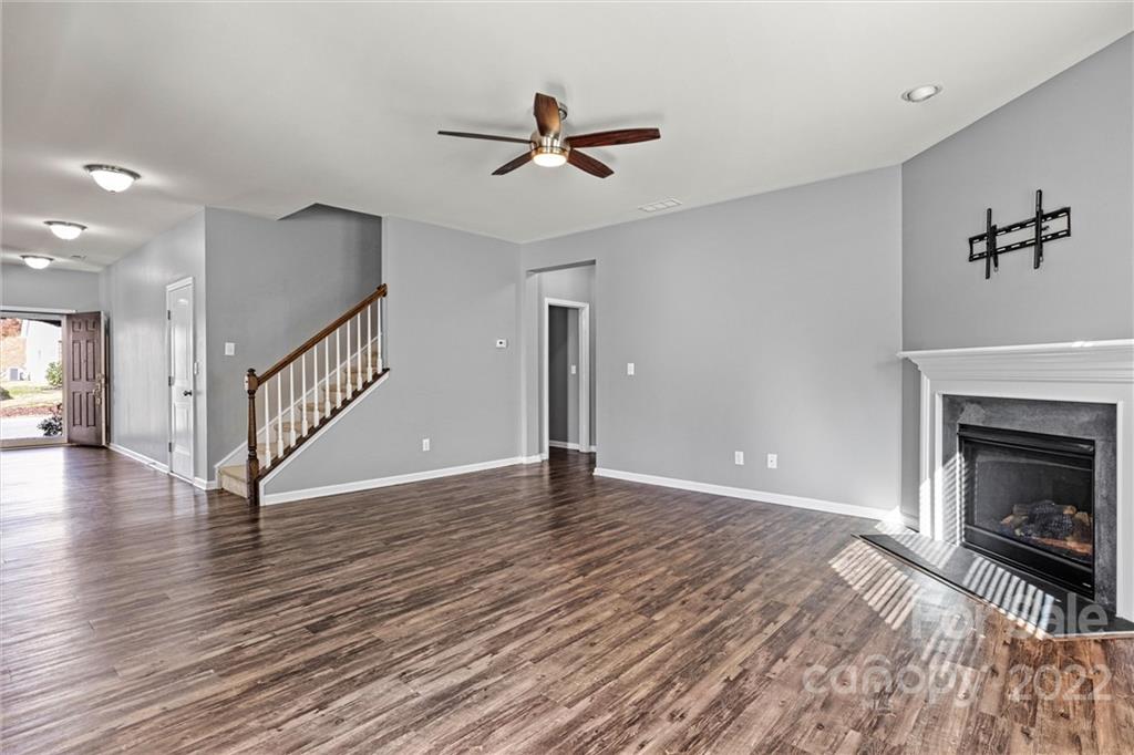 6170 Durango Way Denver, NC 28037 - Photo 7 of 38 a view of an empty room with wooden floor a fireplace and a window
