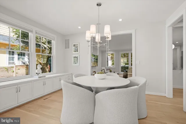 a room with kitchen island granite countertop a stove a sink a center island and windows