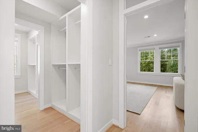 a view of hallway with a large window and wooden floor