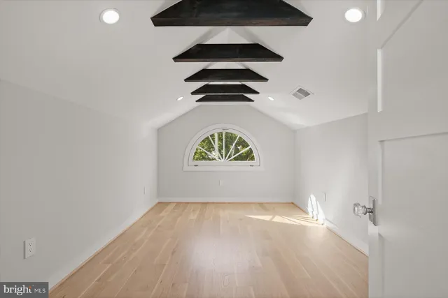 an empty room with a window and wooden floor