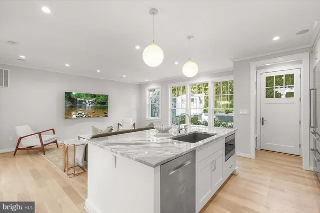 a kitchen with stainless steel appliances granite countertop a stove and a large window