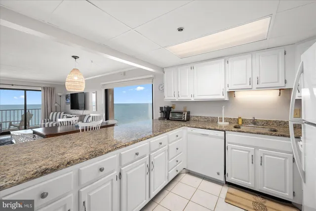 a kitchen with granite countertop white cabinets and white appliances
