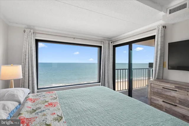 a bedroom with a bed and a flat tv screen next to a window