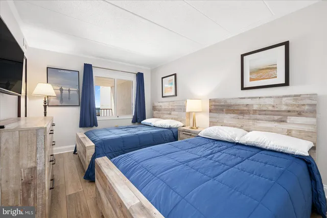 a bedroom with two beds and a night stand