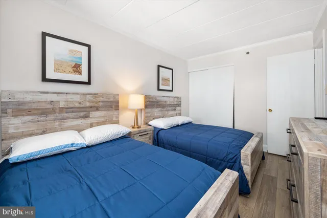 a bedroom with two beds and painting on the wall