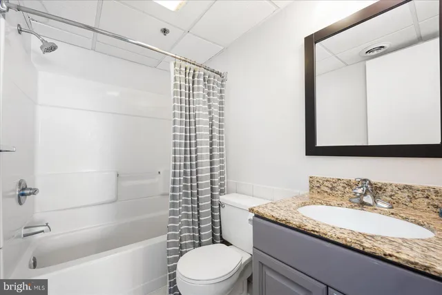 a bathroom with a granite countertop toilet sink and shower