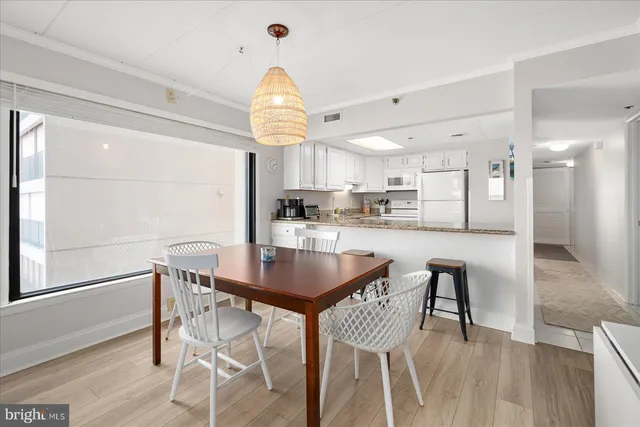 a kitchen with kitchen island a dining table and chairs