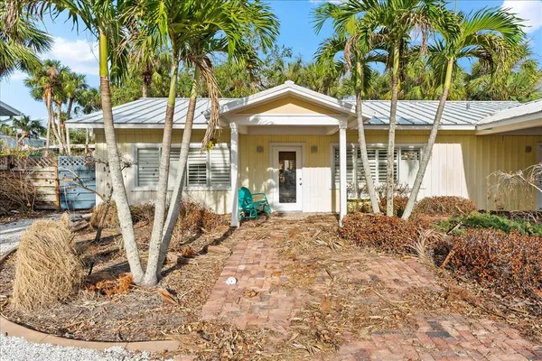 a front view of a house with a yard and potted plants
