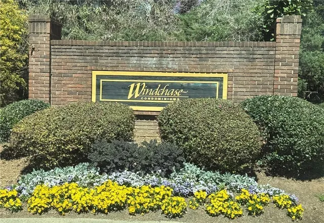 an empty room with wooden floor fireplace and windows