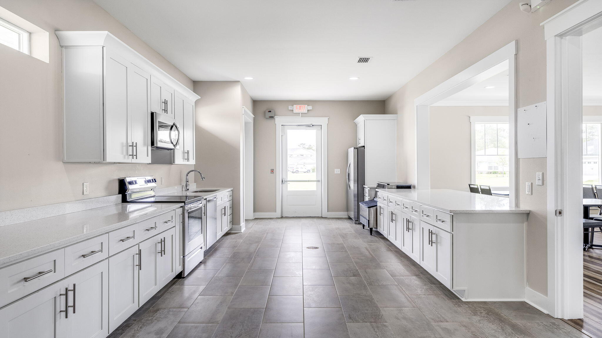255 Riverwalk Circle Freeport, FL 32439 - Photo 32 of 40 a large white kitchen with a sink and dishwasher a stove with wooden floors
