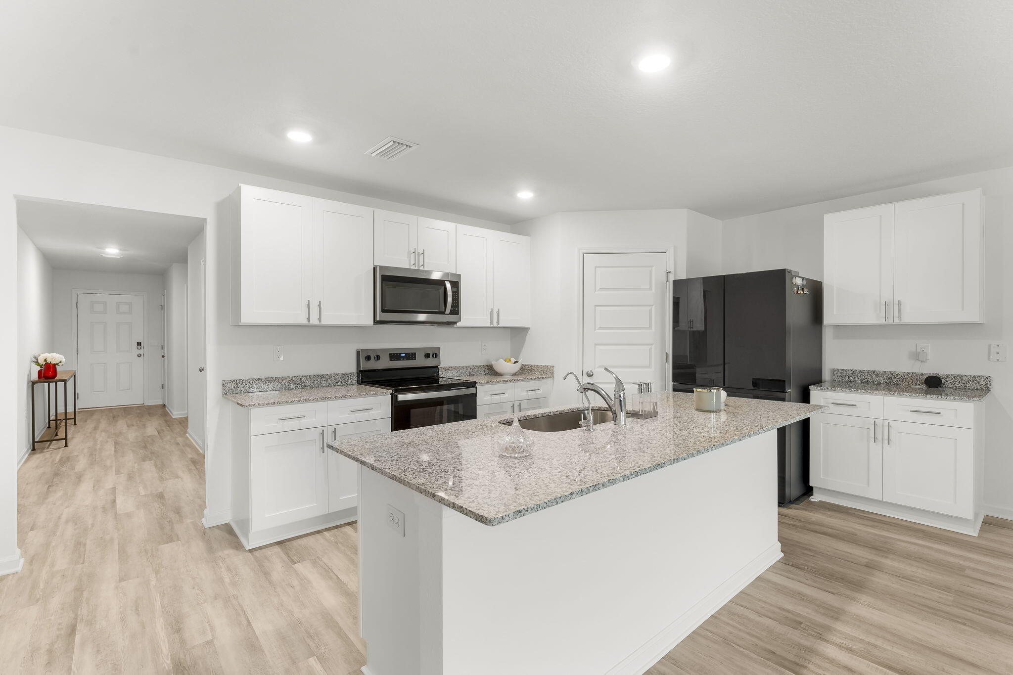 255 Riverwalk Circle Freeport, FL 32439 - Photo 6 of 40 a kitchen with white cabinets and stainless steel appliances